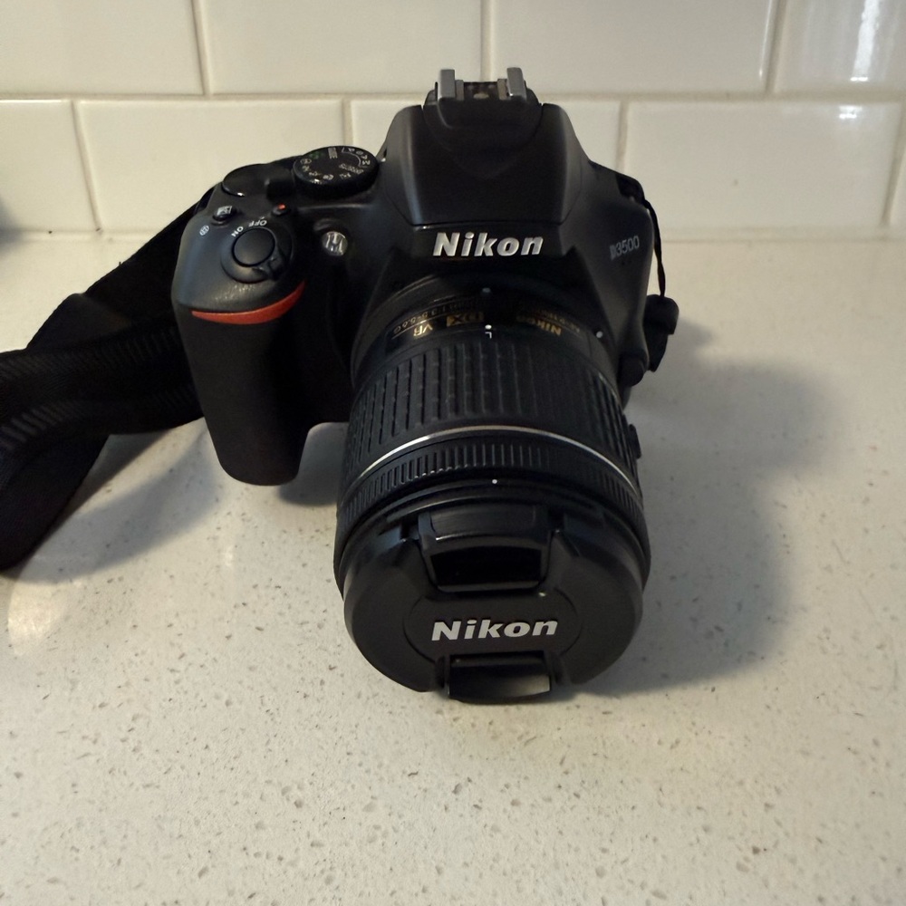 Nikon Black DSLR D3500 with an attached lens